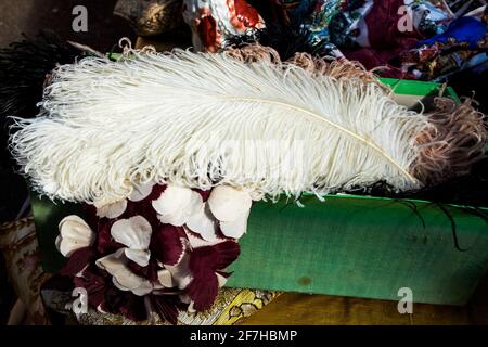 Liverpool Street, Londres, Royaume-Uni,- 21 septembre 2020, marché aux antiquités de Spitalfields. Une grande plume d'autruche blanche repose sur une boîte de foulards en soie Banque D'Images