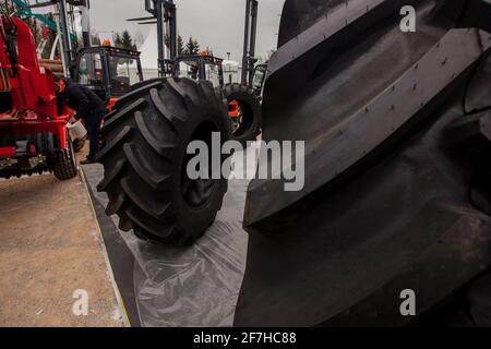 Gros pneus de tracteur exposés dans un salon d'affaires à la campagne. Détail de la bande de roulement d'un pneu. Banque D'Images