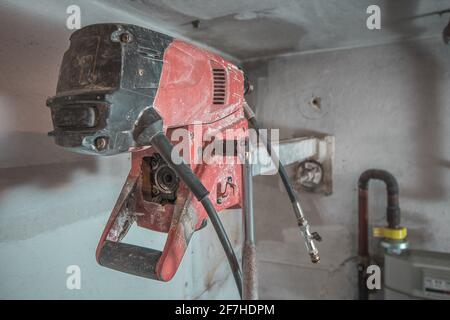 Machine pour percer des trous dans le mur en béton. Perceuse professionnelle rouge pour percer des trous dans les murs. Vue arrière. Banque D'Images