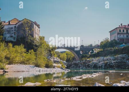 Célèbre pont sur le village de Kanal ob Soci pendant la chaude journée d'été avec la rivière froide Soca coulant sous le pont. Vue sur la grenouille d'un pont à Kanal. Banque D'Images