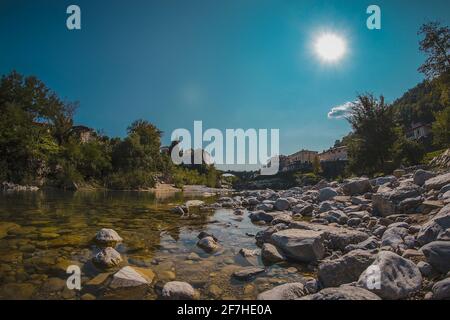 Célèbre pont sur le village de Kanal ob Soci pendant la chaude journée d'été avec la rivière froide Soca coulant sous le pont. Vue sur la grenouille d'un pont à Kanal. Banque D'Images