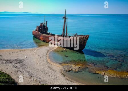 Photo aérienne de l'épave de Dimitrios à Gythio, Grèce. Un naufrage en métal rouillé partiellement coulé qui se défait dans le temps sur une plage de sable par une journée ensoleillée. Banque D'Images