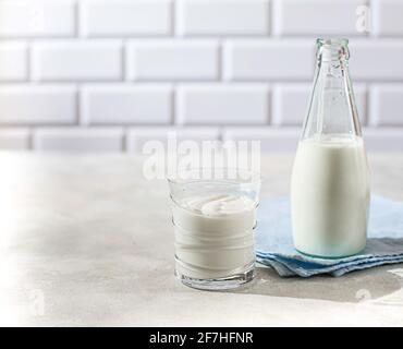 Boisson fermentée kéfir, yaourt dans un pot en verre sur fond clair. Boisson laitière fermentée froide probiotique. Concept de flore intestinale saine. Copier l'espace Banque D'Images