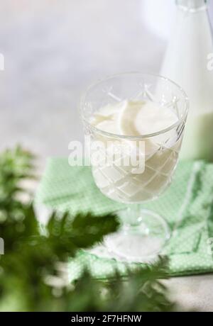 Boisson fermentée kéfir, yaourt dans un pot en verre sur fond clair. Boisson laitière fermentée froide probiotique. Concept de flore intestinale saine. Copier l'espace Banque D'Images
