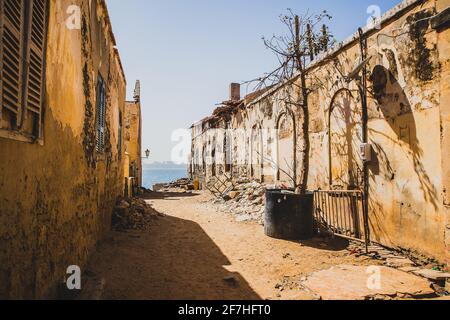 L'une des rues les moins atristes de la célèbre île esclave de Goree. Rangée de maisons avec de la saleté et des déchets sur le sol. La ville de Dakar est vue dans le b Banque D'Images