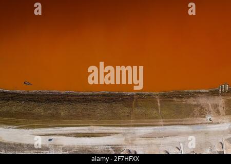 Vue aérienne du lac Rose ou du lac Retba au Sénégal, directement depuis le dessus. Lac rose ou presque orange montrant la beauté naturelle et la richesse des couleurs sur un soleil Banque D'Images