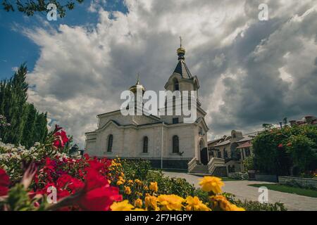 Magnifique paysage de rochers et d'arbres au monastère Orheiul Vechi en Moldavie, par une belle journée d'été. Vue sur le bâtiment principal de l'église avec des fleurs Banque D'Images