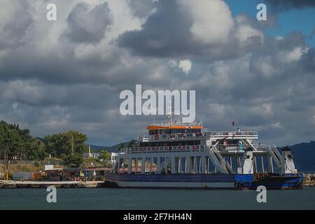 Ferry transportant des personnes et des voitures à travers le détroit de Dardanele entre les villes d'Eceabat et de Canakkale, Turquie, par une journée nuageux. Banque D'Images