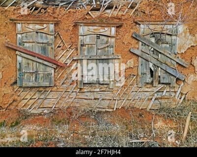 Mur et volets sur les fenêtres de la maison en adobe émiettant abandonné par ses propriétaires dans la région déprimée Banque D'Images