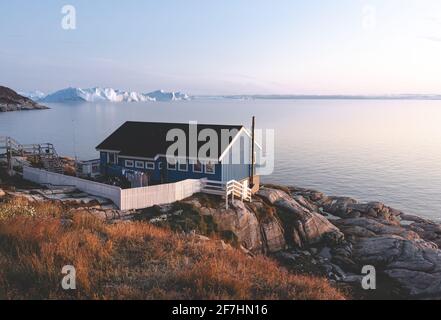 La maison colorée d'Ilulissat, Groenland. Kangia icefjord recouvert de brouillard en arrière-plan avec des icebergs. Concept de réchauffement climatique. Banque D'Images