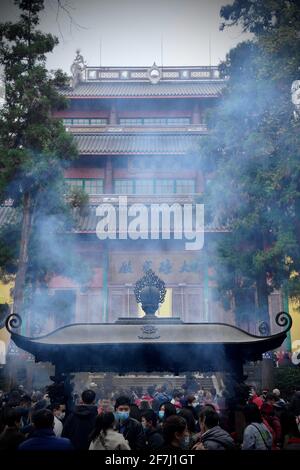 Beaucoup de fumée sort du censeur avec des gens qui prient devant le temple du bouddhisme à Hangzhou, Zhejing, Chine. Banque D'Images