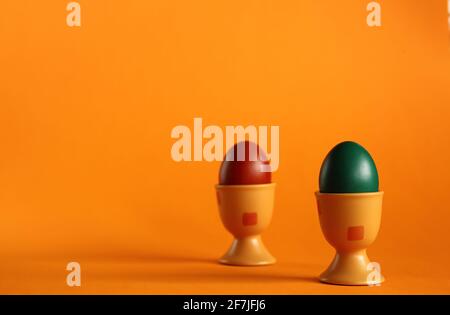 Deux œufs de pâques peints traditionnellement en coquilles d'aubergines sur fond orange. Banque D'Images