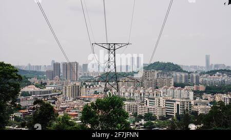 Lignes électriques haute tension dans les collines au-dessus de la ville. Banque D'Images