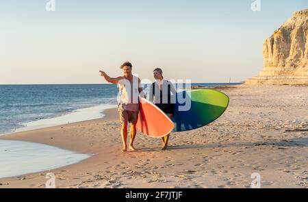 Couple d'âge mûr avec planches de surf sur la belle plage appréciant le paradis et le style de vie actif. Un homme et une femme séduisants surfent et s'amusent. Dans trave Banque D'Images