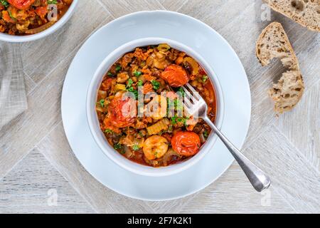 Ragoût de chorizo, lentilles et crevettes avec tomates rôties - vue en hauteur Banque D'Images