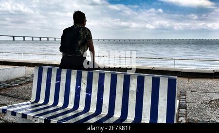 Lisbonne, Portugal - 4 juin 2018 : une femme regardant l'horizon dans le Tage, dans une journée nuageux de printemps à Lisbonne, Portugal. Blanc et bleu dénudés Banque D'Images