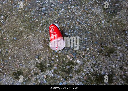 Coupe de papier avec Coca Cola laissée dans un lieu public dans une rue à Bucarest, Roumanie, 2021 Banque D'Images