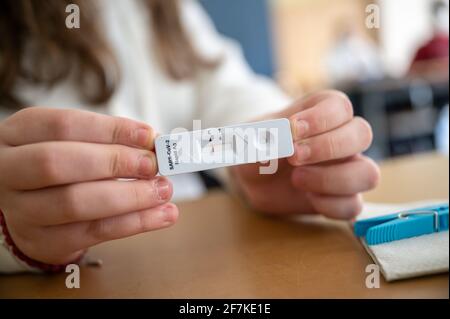 08 avril 2021, Rhénanie-Palatinat, Mayence: Une fille montre son test rapide négatif Corona dans une classe de la Anne-Frank-Realschule. Après les vacances de Pâques, les cours scolaires en Rhénanie-Palatinat ont commencé en mode alternatif - accompagnés, entre autres, de tests rapides dans les écoles. Photo: Sebastian Gollnow/dpa Banque D'Images