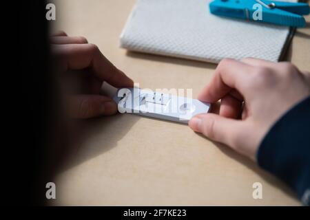 08 avril 2021, Rhénanie-Palatinat, Mayence: Une fille tient son test rapide négatif Corona dans une classe de la Anne-Frank-Realschule. Après les vacances de Pâques, les cours scolaires en Rhénanie-Palatinat ont commencé en mode alternatif, accompagnés entre autres de tests rapides dans les écoles. Photo: Sebastian Gollnow/dpa Banque D'Images