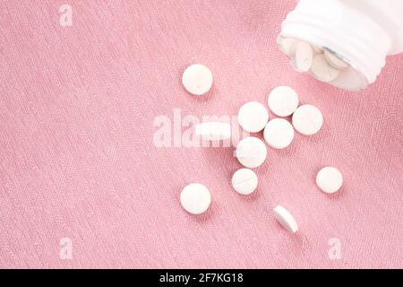 gros plan de pilules médicales de couleur blanche sur fond rose Banque D'Images