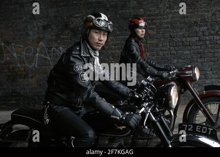 Motard homme et femme , coureur de café portant des vestes en cuir noir assis sur la moto britannique classique à Londres, Royaume-Uni Banque D'Images