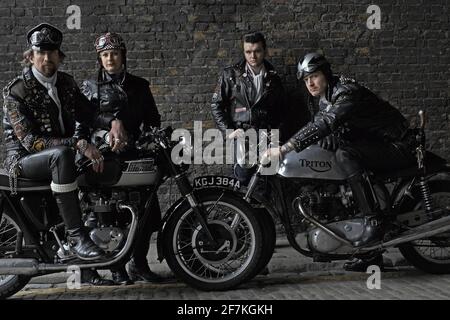 Jeu de rocker posant avec des motos Triumph,Triton classiques britanniques . Rockers sur des motos classiques de course de café à Londres, Royaume-Uni. Banque D'Images