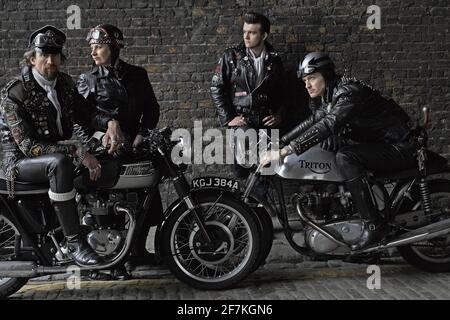 Jeu de rocker posant avec des motos Triumph,Triton classiques britanniques . Rockers sur des motos classiques de course de café à Londres, Royaume-Uni. Banque D'Images