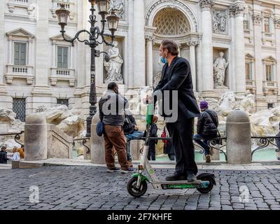 Italie, Rome, 11 mars 2021 : personnes à bord d'un scooter électrique en face de la fontaine de Trevi photo © Fabio Mazzarella/Sintesi/Alamy stock photo Banque D'Images