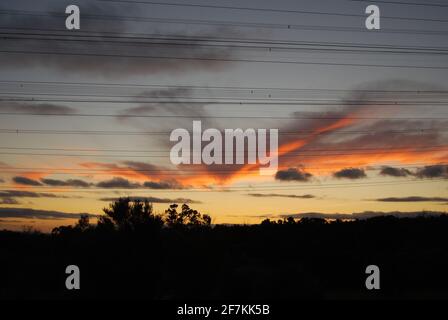 Vue sur le coucher du soleil à travers les lignes électriques depuis le parc national de Churchill, Victoria, Australie Banque D'Images