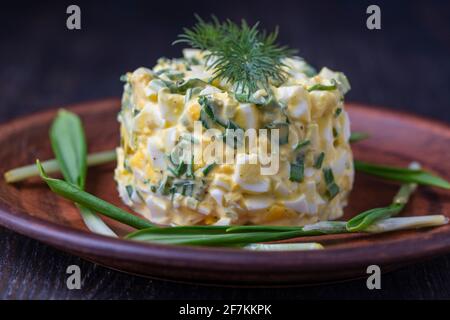 Salade saine de poireaux sauvages verts, œuf poché et crème sure dans l'assiette, gros plan. Salade d'ail sauvage avec œufs durs Banque D'Images