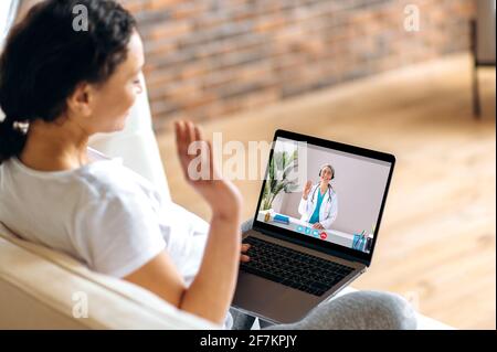 Aide médicale à distance, consultation médicale en ligne. Une femme enceinte parle avec une femme médecin par appel vidéo utilise un ordinateur portable, obtient une consultation médicale, reçoit des réponses aux questions et des recommandations Banque D'Images