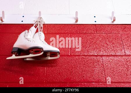 Figure patins suspendus au-dessus du mur rouge dans le vestiaire avec espace de copie. Vue de dessous Banque D'Images