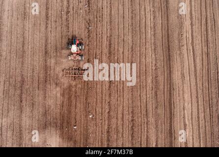 Tracteur travaillant dans les champs, vue aérienne. Le foin sur le terrain. La vue du sommet. Les récoltes du tracteur de l'herbe sèche. Banque D'Images