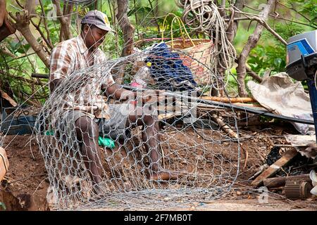 Pêcheur local réparant son piège de pêche sur la belle île de rodrigues, océan indien, maurice Banque D'Images