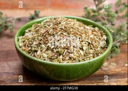 Cuisine aromatique séchée origan aux herbes dans un bol vert gros plan Banque D'Images