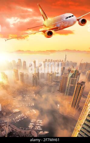 L'avion survole la marina de Dubaï contre un coucher de soleil coloré dans la ville de Dubaï, aux Émirats arabes Unis Banque D'Images