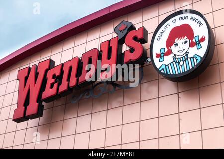 London Ontario, Canada - février 15 2021 : franchise de Wendy's Canada le matin d'hiver bleu, vue de la rue avec la feuille d'érable canadienne. Banque D'Images