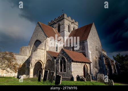 La Boxgrove de l'église du Prieuré de Saint Mary et Saint Blaise lors d'une journée d'automne ensoleillée, éclairée par la lumière du soleil et les nuages de tempête sombre qui s'accumulent au-dessus. Banque D'Images