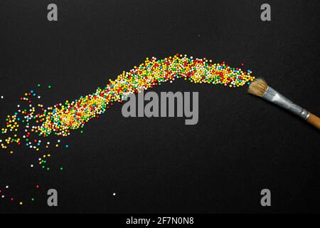 un pinceau laisse une trace de petites boules colorées Banque D'Images