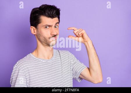 Photo de funky drôle malheureux contrarié douteux homme montrant minuscule petite taille isolée sur fond violet Banque D'Images