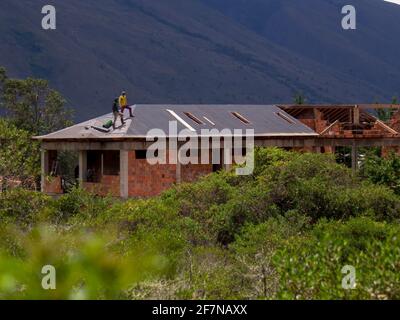 Deux hommes travaillant sur un toit, dans une maison près de la ville coloniale de Villa de Leyva, Colombie. Banque D'Images