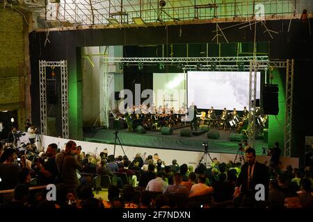 Le public lors d'une représentation de l'orchestre du Watar, jouant pour la première fois sur le terrain du Spring Theatre Hall, Détruit pendant l'occupation de l'EI dans la ville.l'orchestre de Watar comprend 36 jeunes hommes et femmes de différentes confessions du gouvernorat de Ninive, dont des musulmans, des chrétiens et des Yazidis, dont l'âge varie entre 8-32 et 20 ans. Banque D'Images