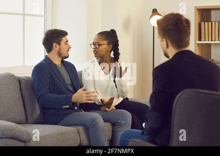 Couple éprouvant des problèmes de relation se blâmant les uns les autres pendant la séance de thérapie Banque D'Images