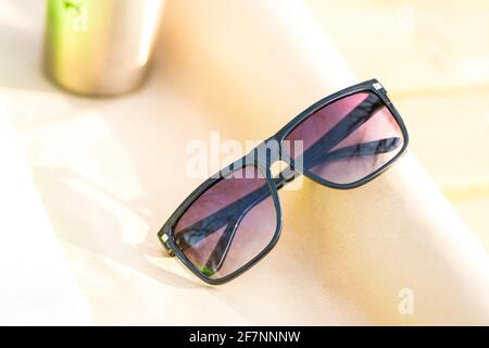 Lunettes de soleil classiques pour hommes et femmes avec verres noirs et cadre noir Shoot à l'extérieur dans une journée d'été gros plan. Mise au point sélective Banque D'Images