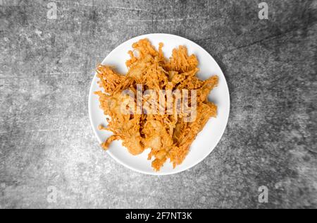 Vue de dessus Mushroom Enoki frits de Crunchy sur la table en béton gris. Banque D'Images