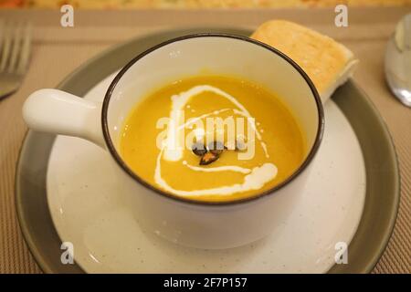 Fermez le bol de soupe chaude à la citrouille, servi avec du pain toast Banque D'Images