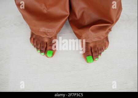 Doigts sur les jambes avec pédicure verte. Beauté afro modèle américain de mode femme brésilienne. Banque D'Images