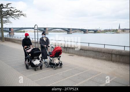 08 avril 2021, Rhénanie-Palatinat, Mayence : deux mères avec protection de la bouche-nez marchent le long de la promenade du Rhin. En arrière-plan, un pont mène au quartier de Wiesbaden de Mayence-Kastell. Les villes voisines de Wiesbaden et de Mayence ont des règles très différentes. (À dpa 'les conclusions dans les règles de Corona: La vue sur le Rhin en attente') photo: Sebastian Gollnow/dpa Banque D'Images