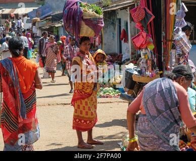 Koraput, Inde - février 2021: Femme d'Adivasi de la tribu Kondh avec son enfant magasiner des légumes dans le marché de Koraput le 21 février 2021 à OD Banque D'Images