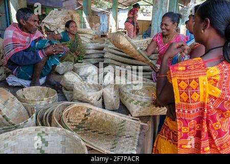 Koraput, Inde - février 2021 : des femmes d'Adivasi de la tribu Kondh achètent des corbeilles de canne sur le marché de Koraput le 21 février 2021 à Odisha, Inde. Banque D'Images